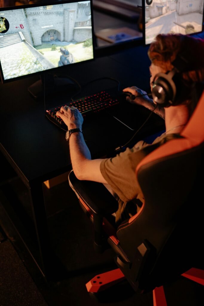 pexels-photo-9072337-9072337 Gamer immersed in video game using PC setup with headphones, indoors at night.